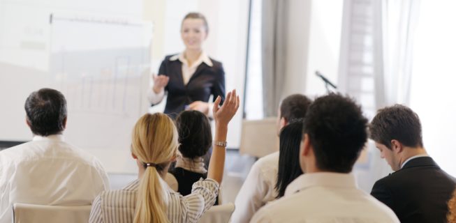 Woman presenting to business people