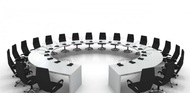 circular conference table with chairs and microphones