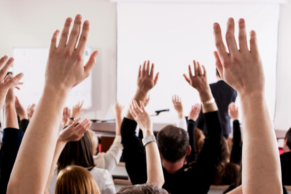 raised hands in the air at a conference