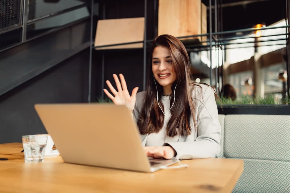 Young woman on laptop taking part in a Virtual Instructor Led Training course