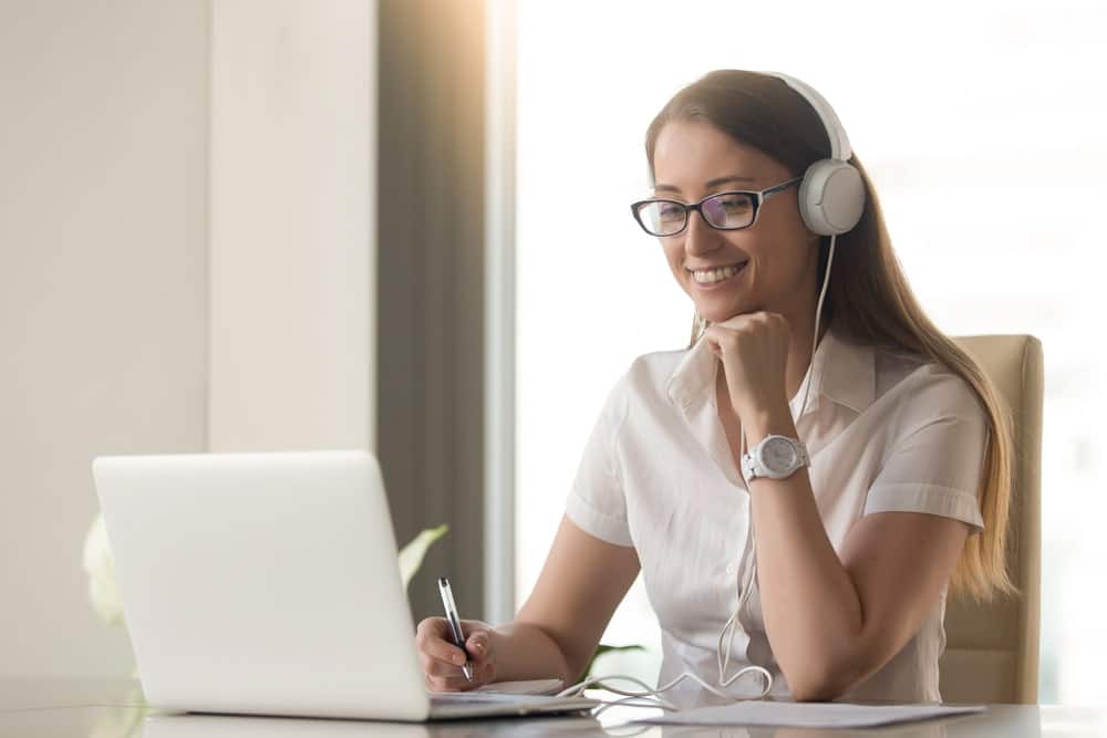 Woman with headphones on laptop presenting online