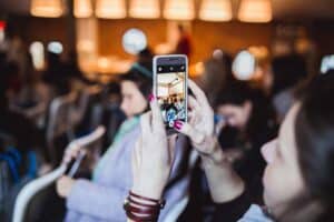girl taking photo with phone at presentation