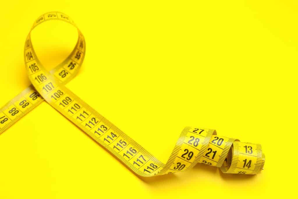 Stylish,Measuring,Tape,On,Yellow,Background,,Closeup