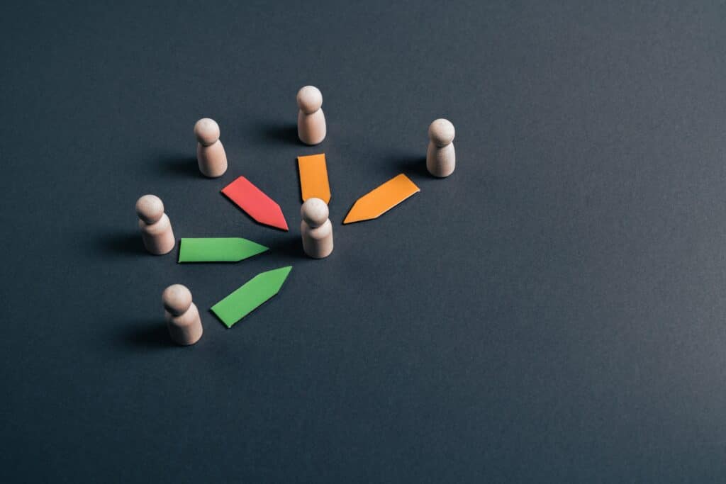 Wooden,Figurines,With,Colored,Arrows,Converging,Toward,A,Central,Figure