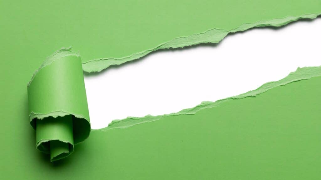 A,Vibrant,Green,Paper,Is,Torn,Diagonally,Across,The,Frame,